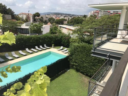 une piscine sur le côté d'un immeuble dans l'établissement Appartement montfleury, 2 terrasses, 2 chambres , 2 sdb , pkg privé piscine, 15 min walk to Croisette beach and Palais des festivals, à Cannes