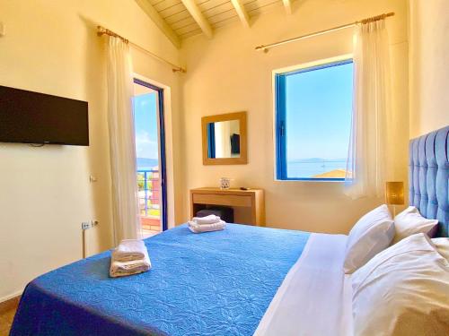 a bedroom with a bed with a blue blanket and a window at Villa Barbati Pelagos with private pool by DadoVillas in Barbati
