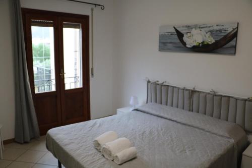 een slaapkamer met een bed met twee handdoeken erop bij La Casa di Magiù in Terrasini