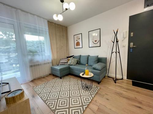 a living room with a blue couch and a table at Apartament za Ratuszem - z balkonem in Radom