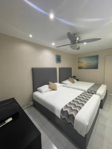 a bedroom with two beds and a ceiling fan at Departamento Cancún in Cancún