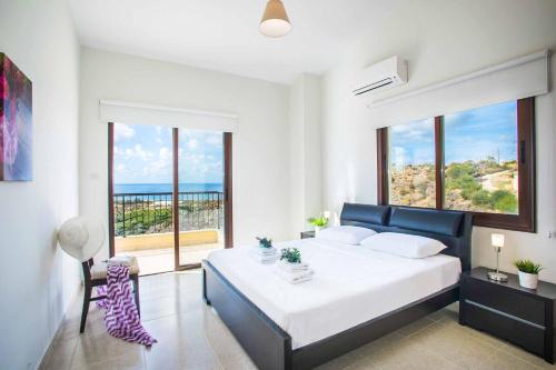 um quarto com uma cama e vista para o oceano em Villa Blue Jadeite em Kissonerga