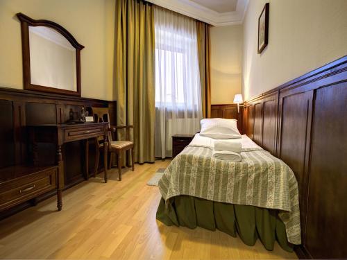 a bedroom with a bed and a desk and a mirror at Hotel Kresowianka in Bydgoszcz