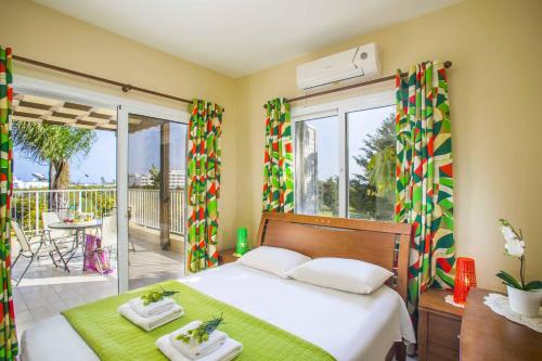 a bedroom with a bed and a balcony at Tropical Beach Villa in Ayia Napa