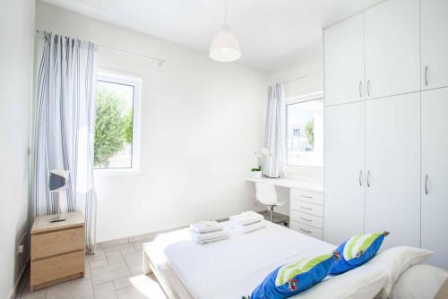ein weißes Schlafzimmer mit einem Bett und einem Fenster in der Unterkunft Villa Melissa Selana in Protaras