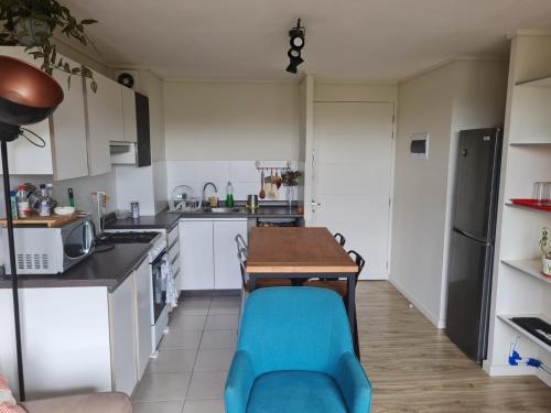 Departamento Osorno 215 في أوسورنو: مطبخ مع طاوله وكرسي ازرق