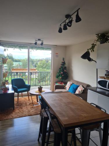 ein Wohnzimmer mit einem Tisch und einem Weihnachtsbaum in der Unterkunft Departamento Osorno 215 in Osorno