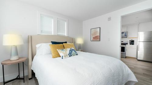a bedroom with a white bed with two pillows on it at Harbourtown Suites on Plymouth Harbor in Plymouth