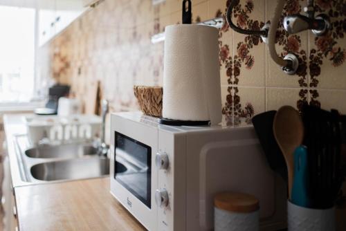 a kitchen with a microwave on top of a counter at Baleal Surf Emotions in Baleal