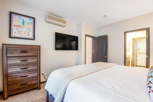 a bedroom with a bed and a dresser and a tv at Arrowhead Ski Condo in Edwards