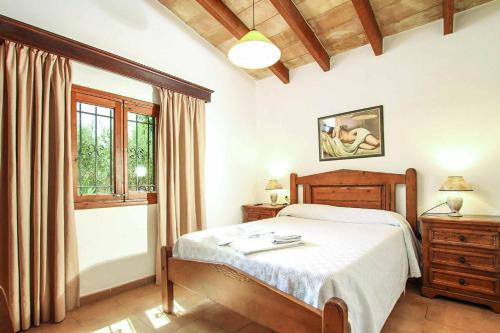 a bedroom with a bed and a window at Villa Bosque in El Port