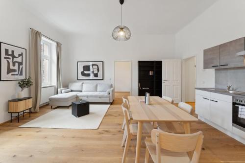 uma cozinha e sala de estar com mesa e cadeiras em Center Wien designer central modern apartment em Viena