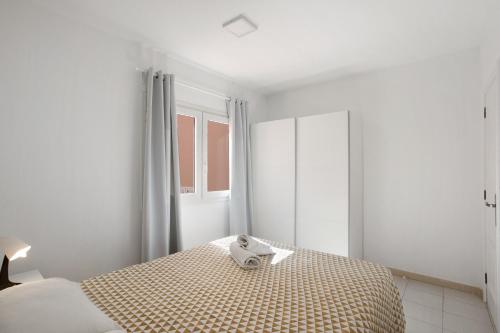 - une chambre blanche avec un lit et une fenêtre dans l'établissement Chipaz Candelaria, à Santa Cruz de Tenerife