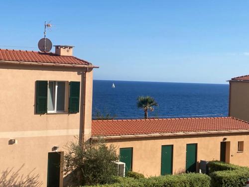 a building with a view of the ocean behind it at Appartamento romantico con piscina in Cervo