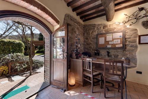 una cocina al aire libre con una pared de piedra y un arco en Le Terre Di Isa, en Magione