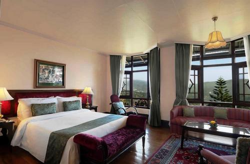 a bedroom with a bed and a living room with a couch at The Elgin Silver Oaks - Heritage Resort & Spa in Kalimpong