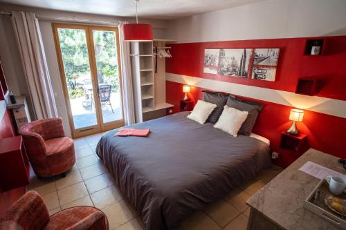 a red bedroom with a bed and a chair at LE LIT QUI DANSE in Mollans-sur-Ouvèze