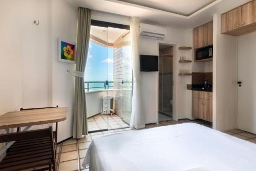 a bedroom with a bed and a view of the ocean at Particular Golden Beira Mar in Fortaleza