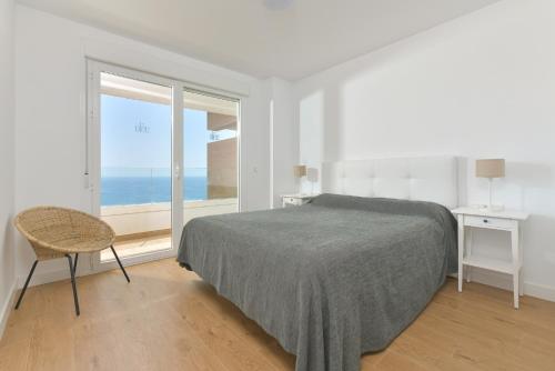 une chambre avec un lit et une vue sur l'océan dans l'établissement Apartamento de lujo de 2 dormitorios, à Torrox Costa