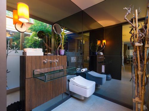 La salle de bains est pourvue de toilettes et d'un lavabo en verre. dans l'établissement Villa Kai by Maspalomas Holiday Villas, à Pasito Blanco