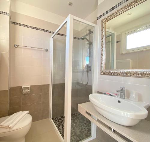 a bathroom with a sink and a toilet and a mirror at Hotel Ravello Adults Only in Rimini