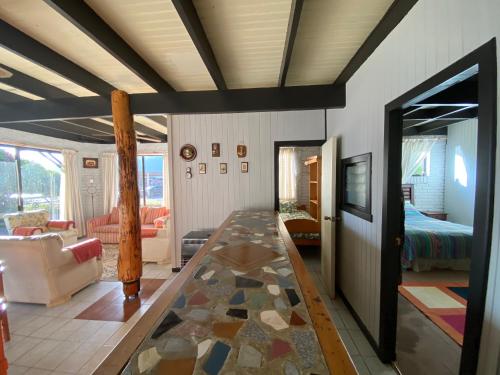 a living room with a table and a bedroom at Cabañas Patagonia LicanRay in Licán Ray