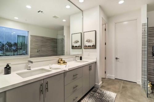 a bathroom with two sinks and a large mirror at Sleek and Modern Home with Views and Pool Access in Indian Wells