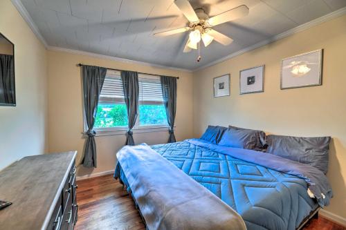 - une chambre avec un lit bleu et un ventilateur de plafond dans l'établissement Charming Harkers Island Home - Fish and Boat!, à Harkers Island