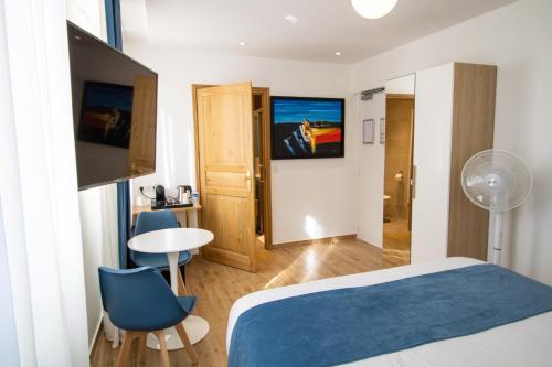 Habitación de hotel con cama, mesa y sillas en Les Rebelles, en París