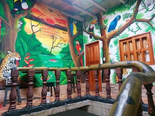 una pared con un mural de árboles y aves en Hostal Selvatrip, en Leticia
