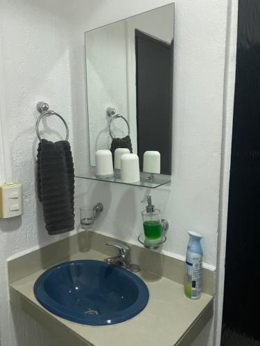 a bathroom with a blue sink and a mirror at Departamento Cancún in Cancún
