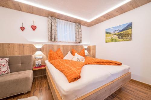 een slaapkamer met een bed met oranje kussens bij Haus Barbara in Sankt Gallenkirch