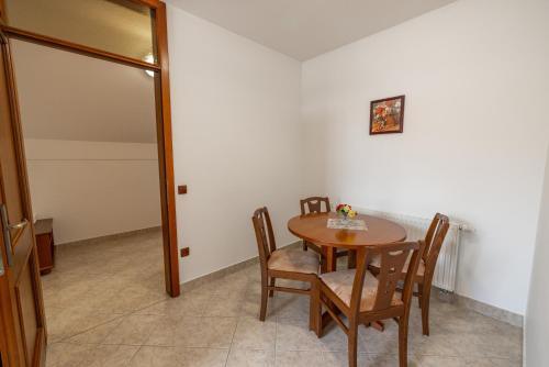a dining room with a wooden table and chairs at Apartments Galunder in Veržej