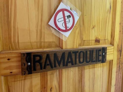 a sign on a wooden wall with a no smoking sign at The Compound in Bijilo