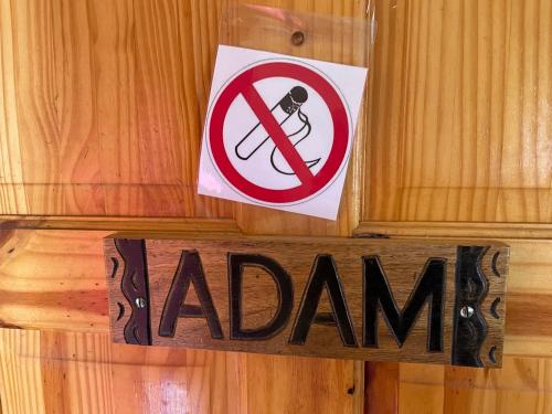 a sign on a wooden wall with a no smoking sign at The Compound in Bijilo