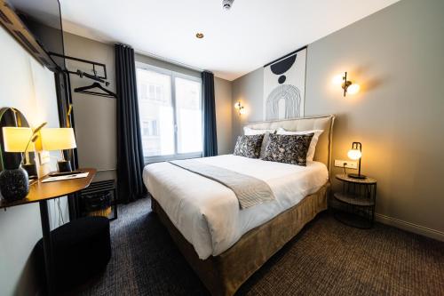 a bedroom with a large bed and a window at Hôtel Paulette Rouen Centre Cathédrale in Rouen