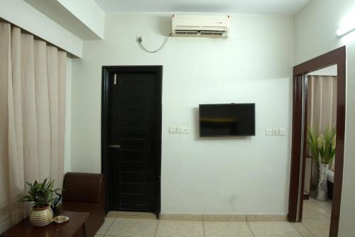 a room with a black door and a tv on a wall at Laguna Beach Hotel & Resort in Cox's Bazar