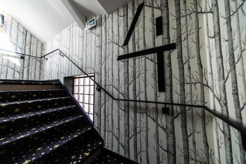 a staircase in a building with trees painted on the wall at Hôtel Paulette Rouen Centre Cathédrale in Rouen