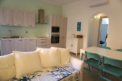a living room with a white couch and a kitchen at Turtle House in Palau