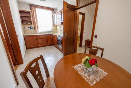 a kitchen with a wooden table with a vase of flowers on it at Apartments Galunder in Veržej