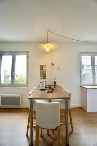 une salle à manger avec une table et des chaises blanches dans l'établissement Le Bellevue *A 2 pas de la mer * Hyper centre*, à Larmor-Plage