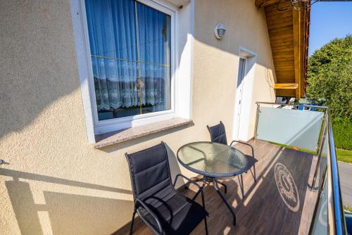 a patio with a glass table and chairs on a balcony at Apartments Galunder in Veržej