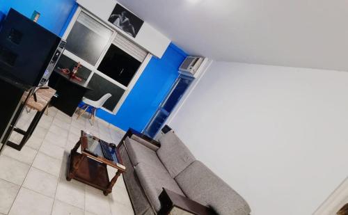 uma sala de estar com um sofá e paredes azuis em Fenix em Buenos Aires