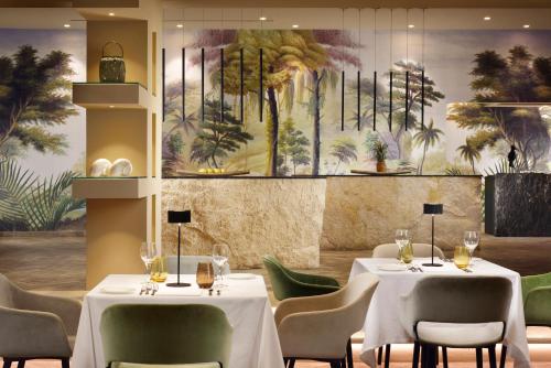 a restaurant with two tables and chairs and a painting at Riva Del Sole Resort & SPA in Castiglione della Pescaia
