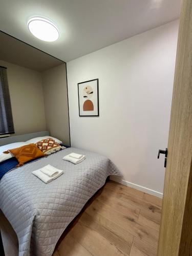 a bedroom with a bed with two towels on it at Apartament w sercu miasta in Radom