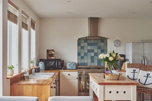 a kitchen with a sink and a stove top oven at Ty Seren in Oxwich