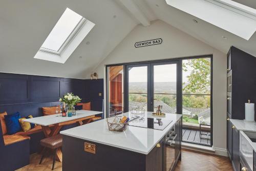 a kitchen with a counter and a dining room at Ty Alice in Oxwich