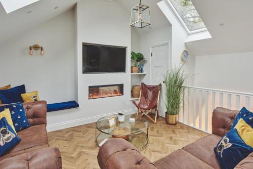a living room with two couches and a fireplace at Ty Alice in Oxwich