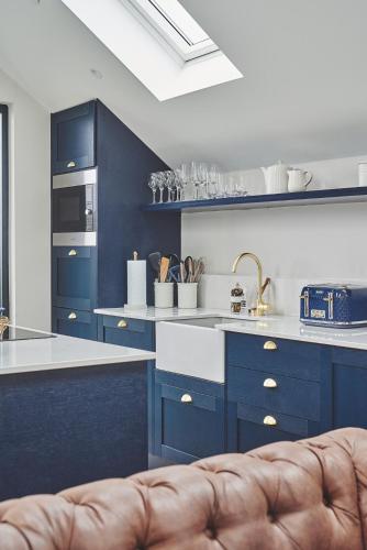 a kitchen with blue cabinets and a sink at Ty Alice in Oxwich