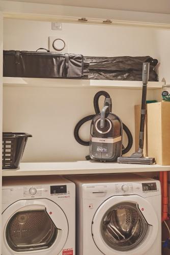 a kitchen with a washing machine and a toaster on a shelf at Ty Alice in Oxwich